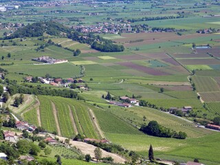 Fototapeta premium panorama seen from above of the plain with the cultivated fields divided into geometric shapes in spring