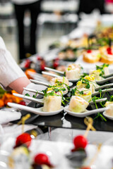 woman hands of a waiter prepare food for a buffet table in a restaurant