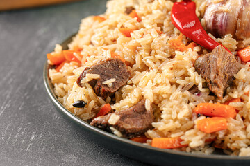 Large dish with Uzbek festive pilaf plov on grey background