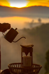 Hand pouring Hot water during brewing arabica coffee by Vintage coffee drip equipment on wooden...
