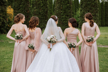 Group portrait of the bride and bridesmaids. Bride in a wedding dress and bridesmaids in pink or...