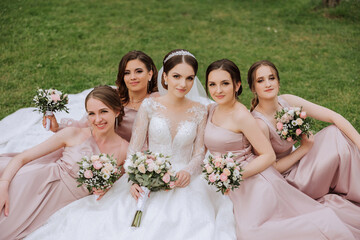 Group portrait of the bride and bridesmaids. Bride in a wedding dress and bridesmaids in pink or...
