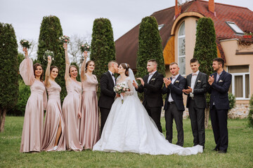 full-length portrait of the newlyweds and their friends at the wedding. The bride and groom with...