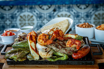 Parrillada de Sonora -Northern-style mixed grill with carne asada steak, mesquite chicken breast, chorizo links, spicy shrimp, Asadero cheese, cactus
paddles, grilled onions, and chile toreado