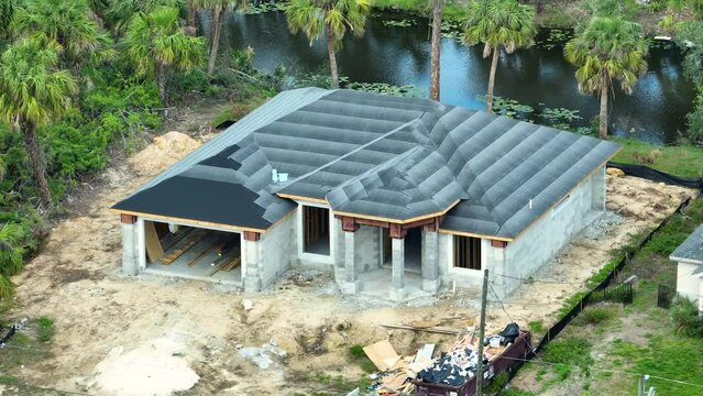 Roof construction. House rooftop covered with asphalt underlayment felt layer ready for installation of shingles. Florida real estate development