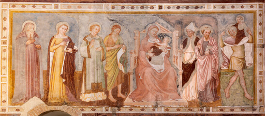 TREVISO, ITALY - NOVEMBER 4, 2023: The fresco of Madonna among the saints  in the church Chiesa di San Francesco by Tommaso da Modena (1350).