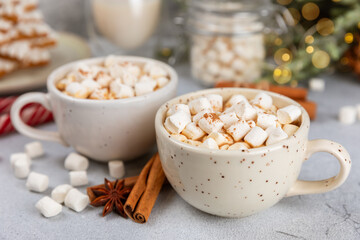 Hot drink with marshmallows and candy cane in cup on texture table.Cozy seasonal holidays.Hot cocoa with gingerbread Christmas cookies.Hot chocolate with marshmallow and spices.Copy space.