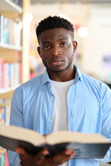 Obraz premium Focused young student studying in a modern library, academic pursuits and learning.