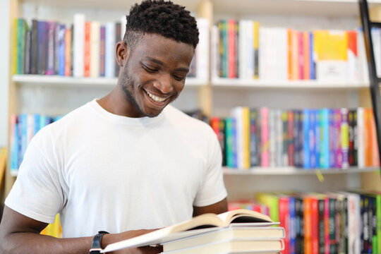 A focused student in a university library, surrounded by books, immersed in academic pursuits, and showcasing a commitment to learning.