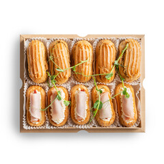 A box of gourmet savory eclairs with cream cheese and rolled ham garnished with fresh herbs, conceptually related to fine pastry or catering