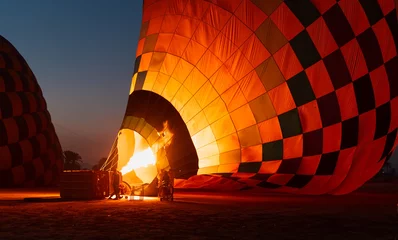 Poster Hot air balloon is inflating before liftoff - Hatshepsut Temple at sunrise in Valley of the Kings and red cliffs western bank of Nile river- Luxor- Egypt © muratart