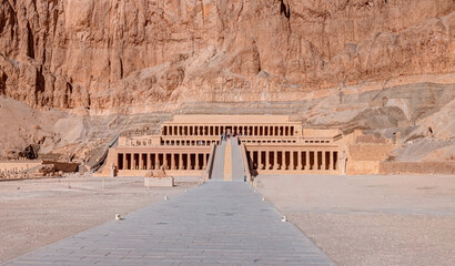 Hatshepsut Temple at sunrise in Valley of the Kings and red cliffs western bank of Nile river -...