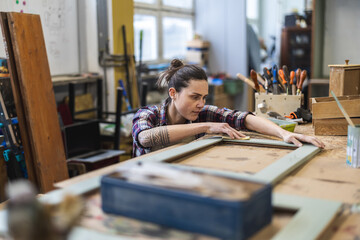 Female carpenter working in her workshop
 - obrazy, fototapety, plakaty