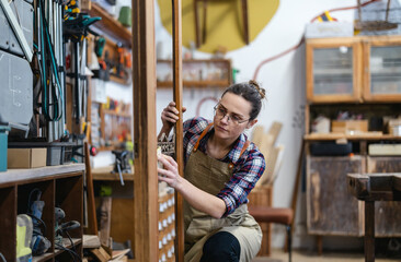 Fototapeta na wymiar Female carpenter working in her workshop 