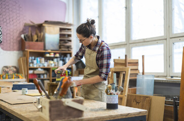 Female carpenter working in her workshop
