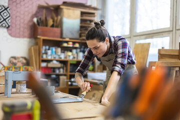 Female carpenter working in her workshop

