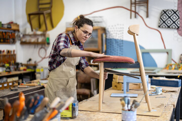 Female carpenter working in her workshop
