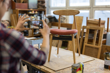 Craftswoman taking photos of a renovated chair
