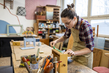 Female carpenter working in her workshop
