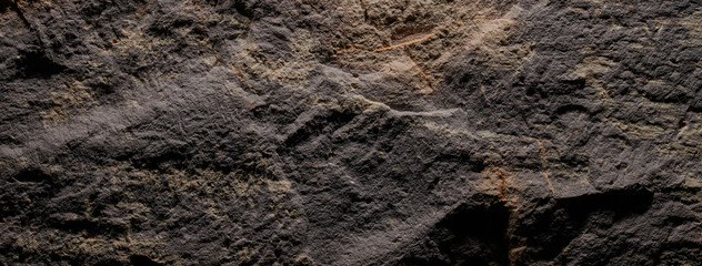 Brown stone texture, dark abstract background. Natural mineral rock close up details, empty backdrop with copy space for design