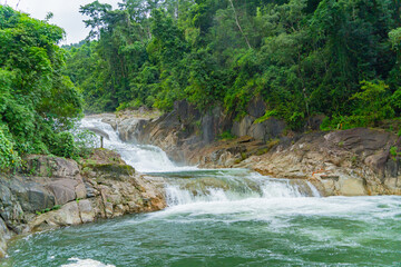 Obraz premium A waterfall in a nature park. Cloudy weather. Yang Bay Ecopark in Vietnam near Nha Trang.