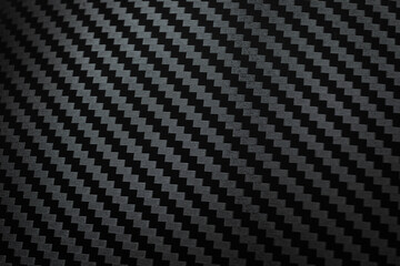 Carbon fiber composite raw material background. Carbon fiber texture. Dark Gray background with lighting.
