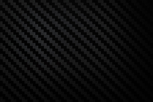 Carbon fiber composite raw material background. Carbon fiber texture. Dark Gray background with lighting.