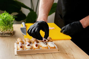 A chef wearing black gloves delicately prepares gourmet canapes, showcasing culinary presentation...
