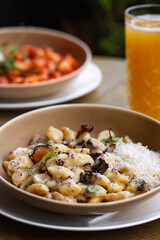 Pappardelle pasta with mushrooms and parmesan cheese on a plate . Traditional Italian gnocchi pasta with mushroom and parmesan cheese