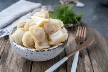Handmade dumplings with greens in rough, handmade dishes. Close-up