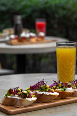 Canapes with avocado, mozzarella cheese and sauce on wooden board . bruschetta