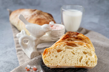 piece of fresh wheat bread with milk close-up. Fresh pastries on the table.