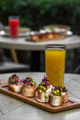 Canapes with avocado, mozzarella cheese and sauce on wooden board . bruschetta