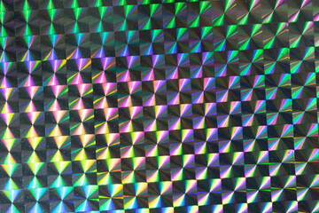 photo of glitter pattern background, silver rainbow disco holographic foil texture, colorful hologram surface.