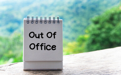 Out Of Office text on notepad with nature background