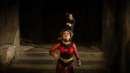 A woman in a red dress tripped and fell in front of a man in a black dress on a staircase