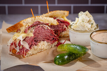 Rachel Sandwich with Pastrami, Swiss Cheese and Coleslaw with potato salad and pickle on the side