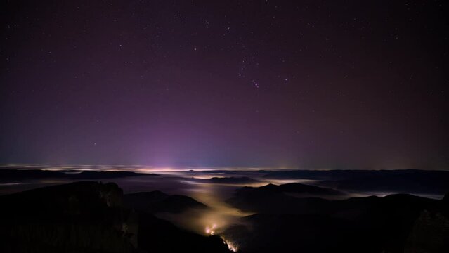 Night stars timelapse in the mountains with moving clouds. Ceahlau National Park, Romania