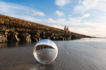 Santos city, Brazil. Crystal ball on the beach sand next to the wall of water channel nº6...