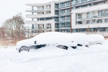 Poland, Krakow, 12.03.2023, snowfall, snowy street with cars after a blizzard