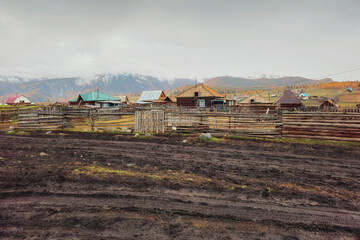 Autumn dirt road, impassable mud through the village. Wet rural road washed out by rains. Altai region.