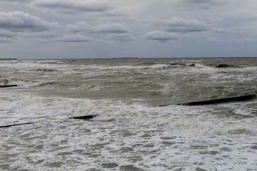 Fototapeta premium seashore on a cloudy day, strong waves, storm, dark blue sky