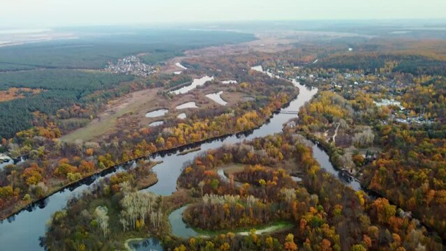 Autumn aerial tilt down view on river dale with forest on riverbanks. Hills of Siverskyi Donets River valley in Ukraine