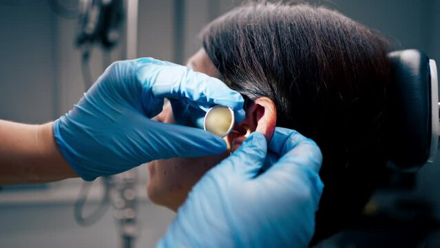 close-up ENT doctor examines the patient's ears in the office of the clinic with professional instruments