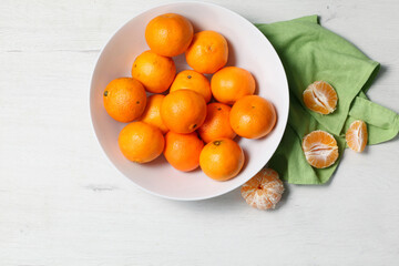 White bowl with fresh tangerines on white background