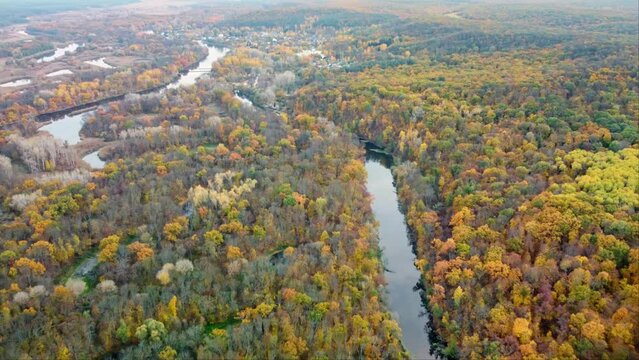 Autumn aerial backwards flight above river with colorful forest on riverbanks. Siverskyi Donets River in Ukraine