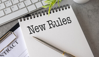 NEW RULES text on the notebook with pen on gray background