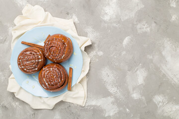 Sweet homemade cinnamon rolls on concrete background, top view