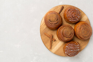 Sweet homemade cinnamon rolls on concrete background, top view