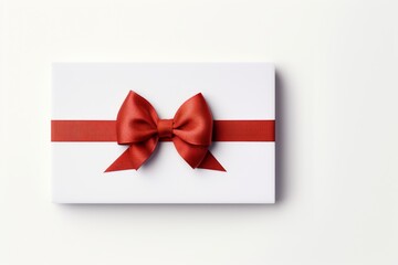 White greeting card or voucher mockup tied with red ribbon and bow on white background top view
